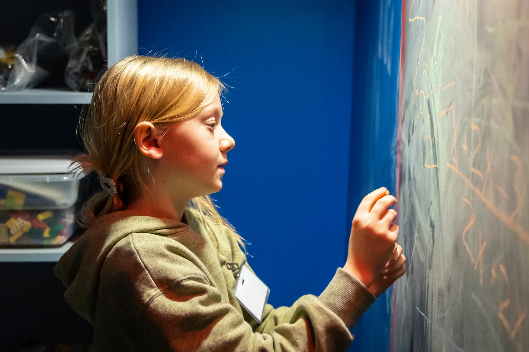 Child Writing on Chalkboard